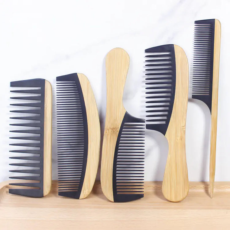 Set of wooden combs with black plastic teeth on a wooden surface.