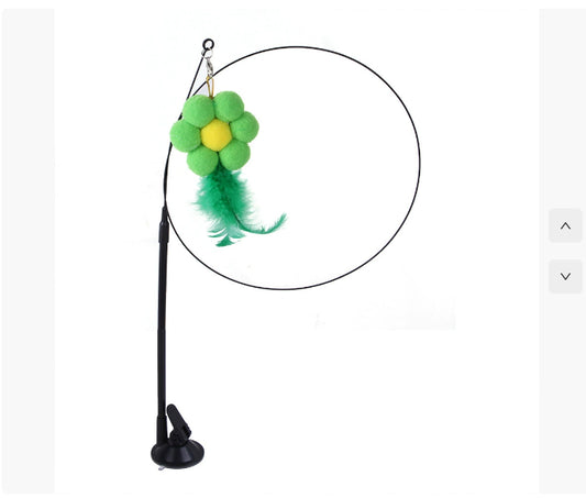 Cat toy with a green flower and yellow center on a black stand against a white background